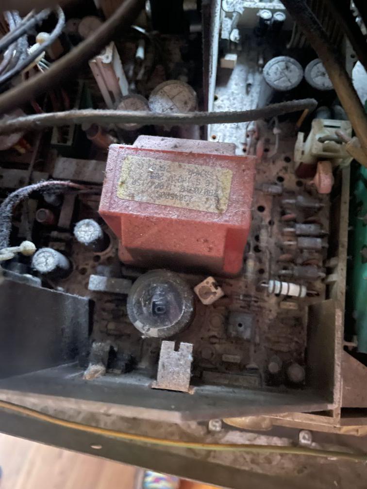 Blick auf den Hochspannungsteil einer Platine aus einem Röhrenmonitor. Im Zentrum des Bildes ist ein hellroter Klotz zu sehen - das ist ein Transformator zur Hochspannungserzeugung. Darunter ein schwarzer, runder Gegenstand - das ist die Kappe eines Kondensators